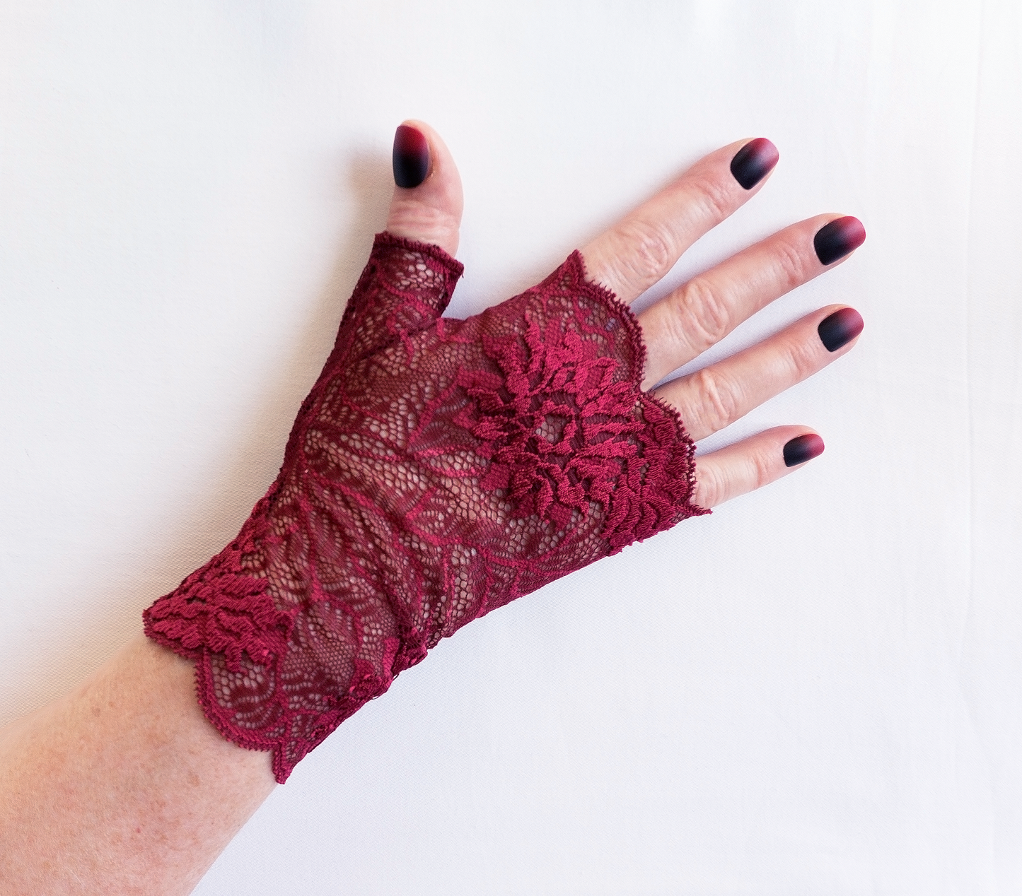 Wrist warmers gloves fingerless made of lingerie lace aubergine magenta patterned with huge flowers 