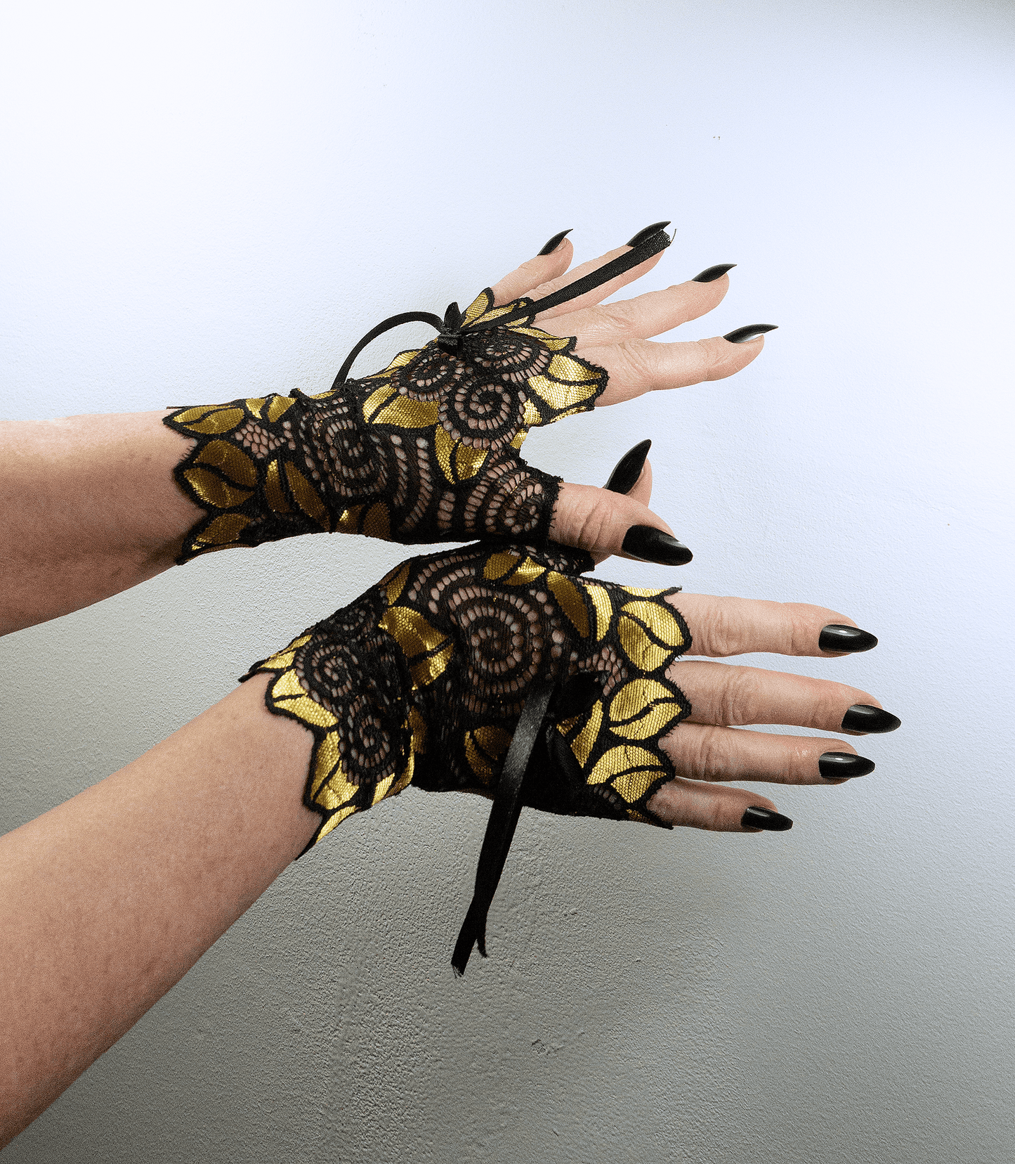auffällige Pulswärmer | Handschuhe fingerlos glänzend mit riesigen Blumen + Schleife in schwarz / gold