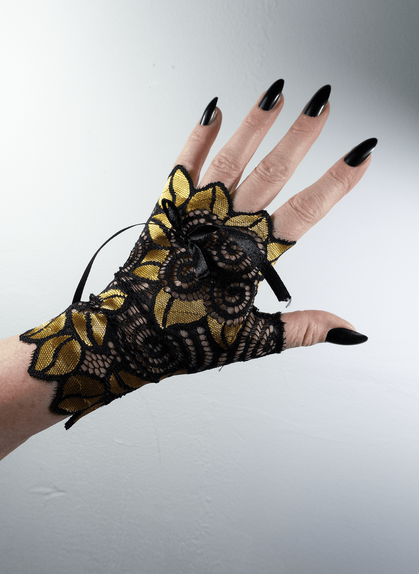 auffällige Pulswärmer | Handschuhe fingerlos glänzend mit riesigen Blumen + Schleife in schwarz / gold