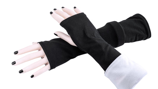 andere Ansicht der Armstulpen in schwarz weiß. Ein paar Damen Arme und Hände übereinander tragen Mouska Alfars Original Stulpen, umgekrempelt. Es gibt verschiedene Tragemöglichkeiten. entweder zwei verschiedene Farben oder beide Farben gleich, umgekrempelt oder lang.