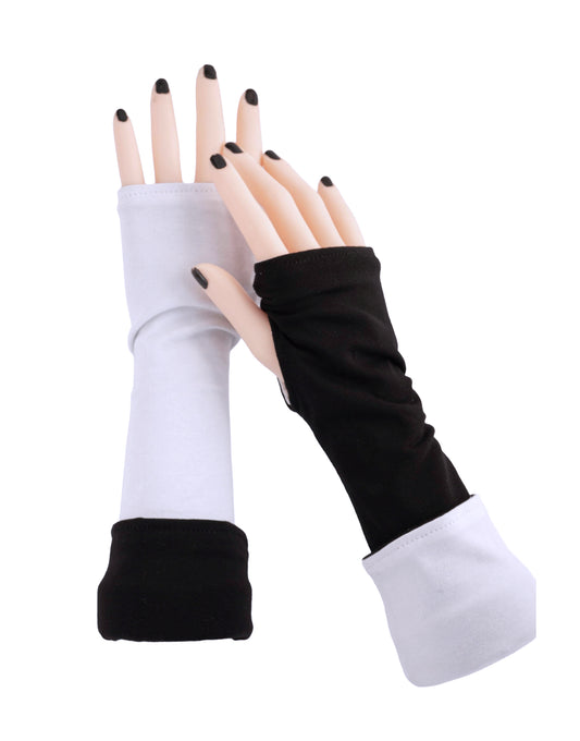 Wende Armstulpen mit Daumenloch. Hergestellt aus Baumwolle Jersey in schwarz weiß abgebildet an zwei Damen Armen / Händen mit schwarzem Nagellack lackierte Nägel. Handarbeit von Mouska Alfar