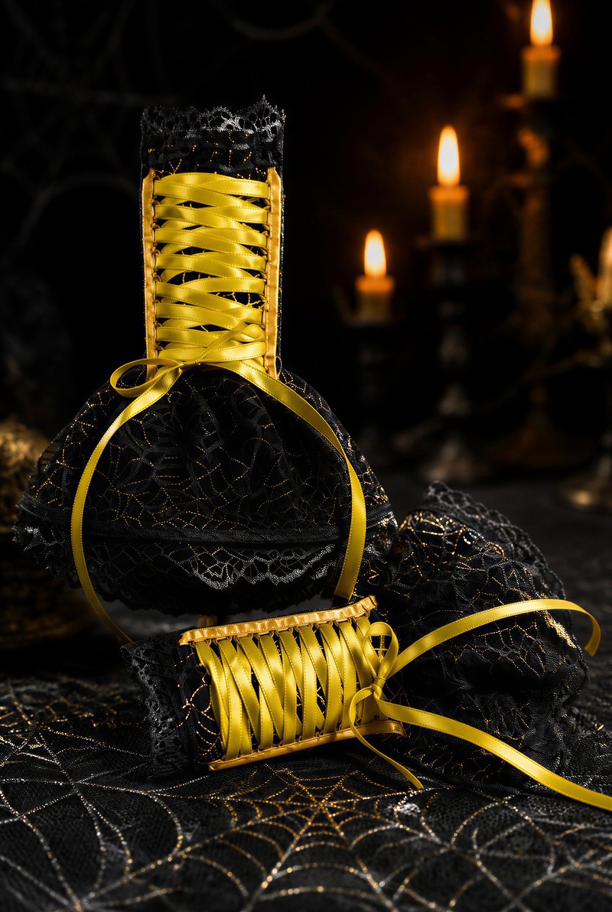 Gothic Halloween Armstulpen mit Röckchen & Schnürung. Spinnennetz aus Samt + Spitze. Handarbeit in schwarz gold. An einem Paar Stulpen dargestellt, eine stehend eine liegend. Spinnen Gothic Ambiente im Hintergrund