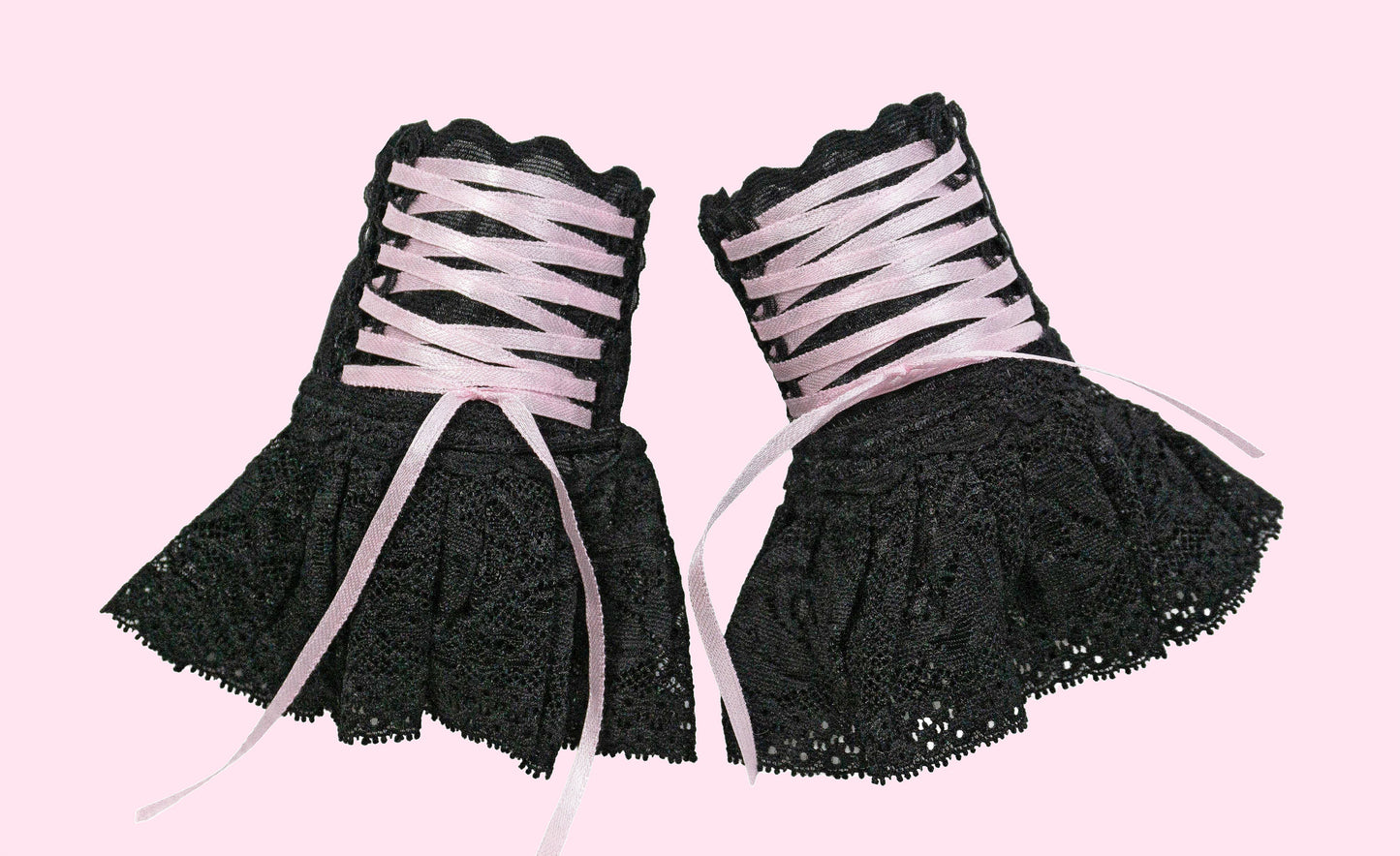 ein weiteres Paar Damen Pulswärmer mit Röckchen im Punk und Gruftie Stil, frei an der Wand stehend abgelichtet, auf baby rosa Hintergrund mit Studio Licht. Hier kann man die Details gut sehen. Sie stehen friedlich nebeneinander und warten auf Ihren Besitzer. Fair & Slow Fashion direkt aus Deutschland. Auf Bestellung in 7 Größen möglich.