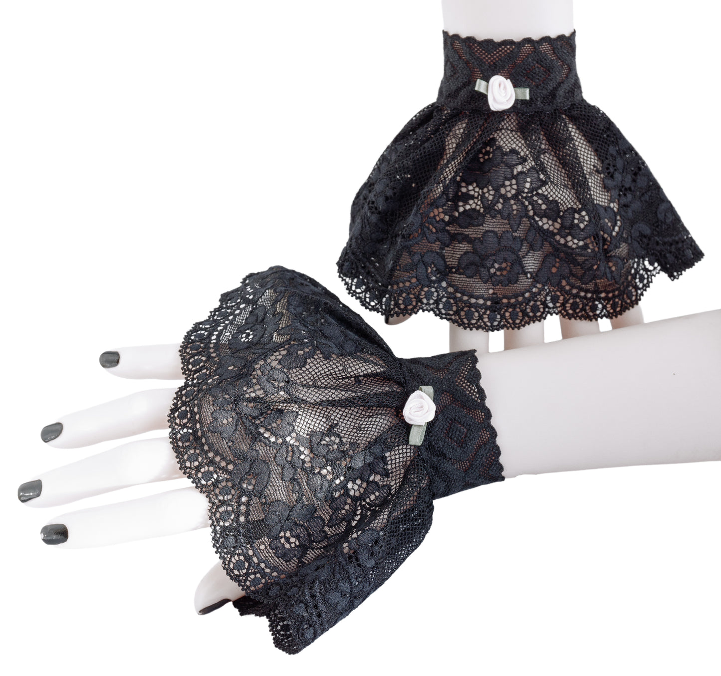 ein paar gothic Manschetten an Damen Händen präsentiert, schwarz lackierte Fingernägel. Hintergrund Studio weißes ambiente. Mini Stulpen in schwarz mit Röckchen schwingend. Eine Stulpe an der Wand stehend, die andere liegend. Handarbeit aus Hamburg, Deutschland von Mouska Alfar Modedesign für Harajuku und Darkfashion.