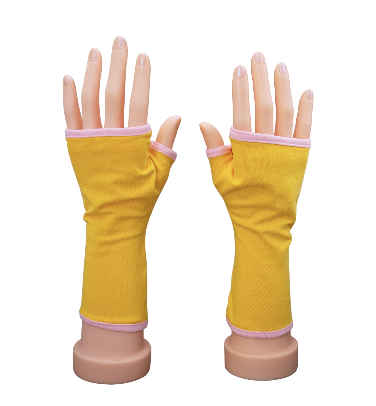 ein Paar Handschuhe ohne Finger an Händen präsentiert, farbe in sonnen gelb und gefüttert mit rosa. Aus Baumwolljersey