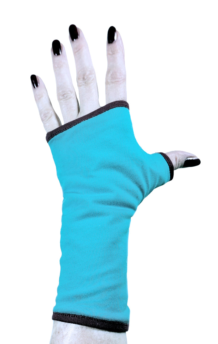 Einzel Basic Handschuh ohne Finger, fotografiert an einer Damenhand, die auf dem Tisch liegt. Bunt lackierte Fingernägel, sehr stylisch und exklusiv. Hintergrund Studio weiss. Aus Baumwolle Jersey mit Paspel, gefüttert. Oberstoff türkis, Futter dunkelbraun