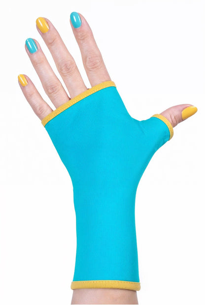 Einzel Basic Handschuh ohne Finger, fotografiert an einer Damenhand, die auf dem Tisch liegt. Bunt lackierte Fingernägel, sehr stylisch und exklusiv. Hintergrund Studio.Aus Baumwolle Jersey mit Paspel, gefüttert. Oberstoff türkis, Futter gelb.