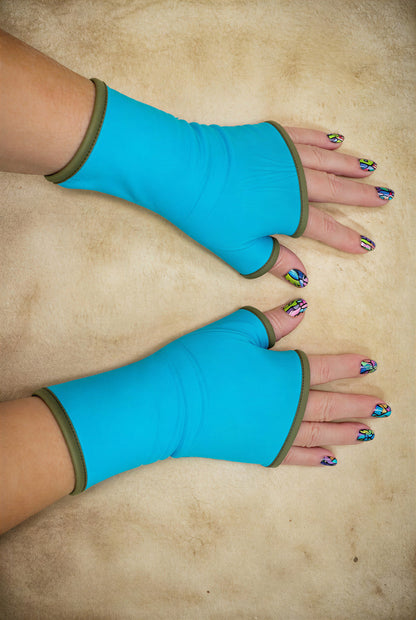 ein Paar Damen unisex Handschuhe aus Baumwolle Jersey mit Paspel, gefüttert. Oberstoff türkis, Futter khaki oliv gruen. An Damenhänden fotografiert die seitlich im Bild liegen und das ganze Foto ausfüllen, mit schönen bunt lackierten Fingernägeln.