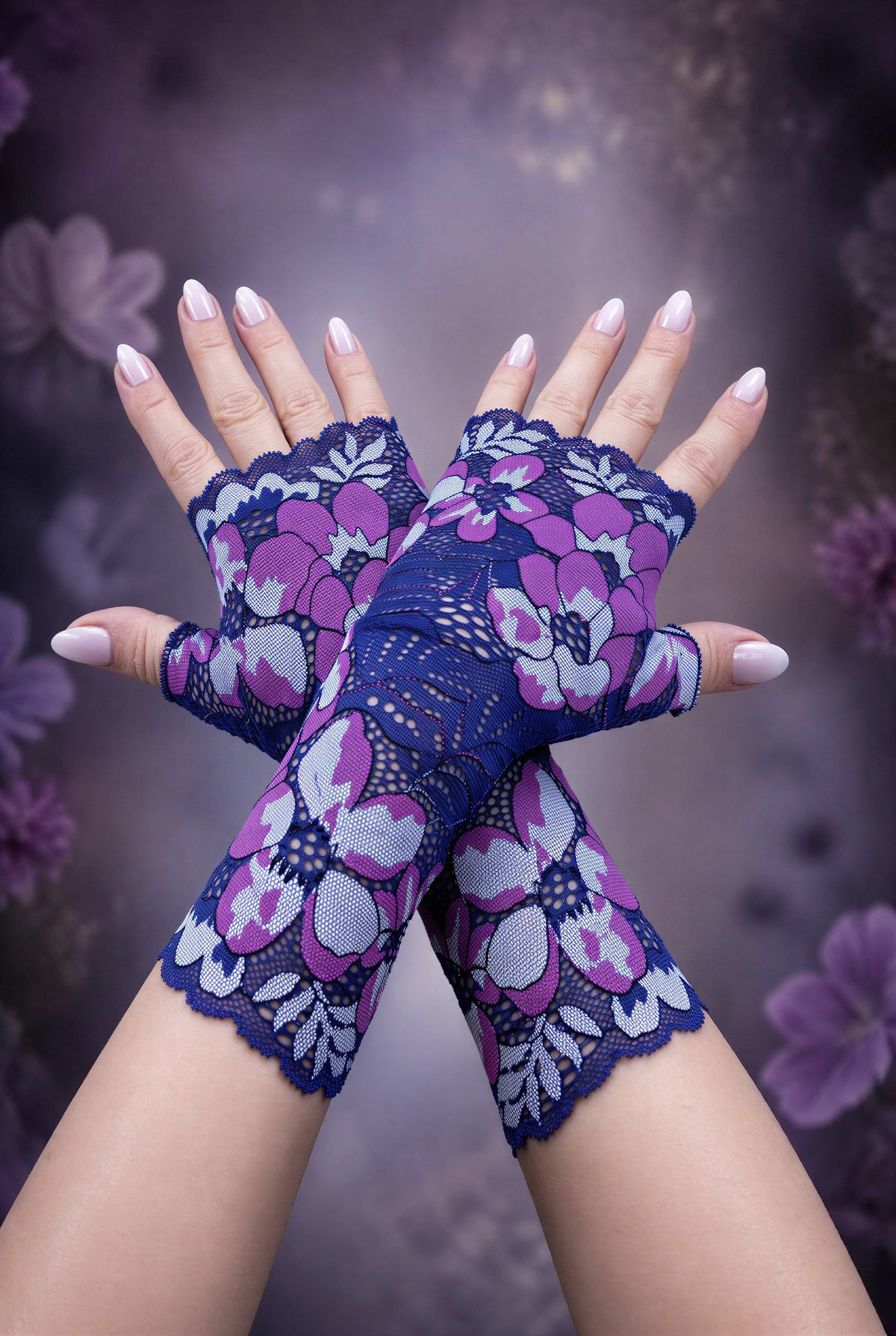 ein Paar lange Boho Hippie Handschuhe in lila blau Tönen übereinander gekreuzt mittig auf dem Foto, lackierte Fingernägel. Die Handschuhe kommen schön zur Geltung. Sie sind vom Grundtenor dunkelblau-violett mit riesigen verstreuten Blumen. Aus Wäschespitze gearbeitet, satte Farben, wunderhübsch.