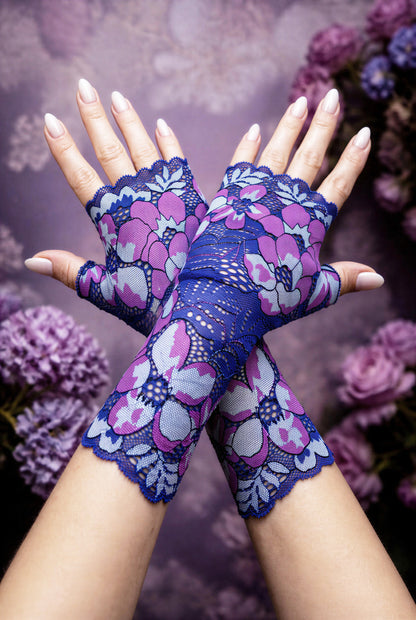 ein Paar lange Boho Hippie Handschuhe in lila blau Tönen übereinander gekreuzt mittig auf dem Foto, lackierte Fingernägel. Die Handschuhe kommen schön zur Geltung. Sie sind vom Grundtenor dunkelblau-violett mit riesigen verstreuten Blumen. Aus Wäschespitze gearbeitet, satte Farben, wunderhübsch.