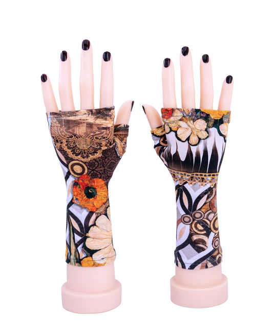 ein paar robuste Damen Handschuhe ohne Finger mit bunt abstrakten Muster in Herbst Tönen,  aus dickem Baumwoll Tricot Jersey von Mouska Alfar, in Handarbeit hergestellt.
Auf dieser Seite an Modellhänden präsentiert, die auf dem Tisch stehen, lackierte Fingernägel, von vorne, frontal.