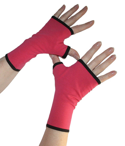 ein Paar Handschuhe fingerlos fotografiert an Damen Händen, Farbe pink mit schwarzen Futter und Paspel, aus Baumwolljesey. Qualität für besten Tragekomfort und mit Daumen zum Reinschlüpfen