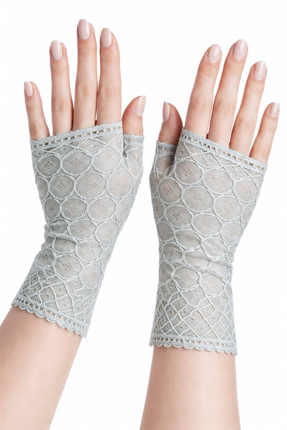 ein Paar Handschuhe an Damen Händen frontal fotografiert, aus weicher leichter Spitze mit geometrischen Art Deco Mustern, Farbe seegras. Sie sind fingerlos aber mit Daumen.