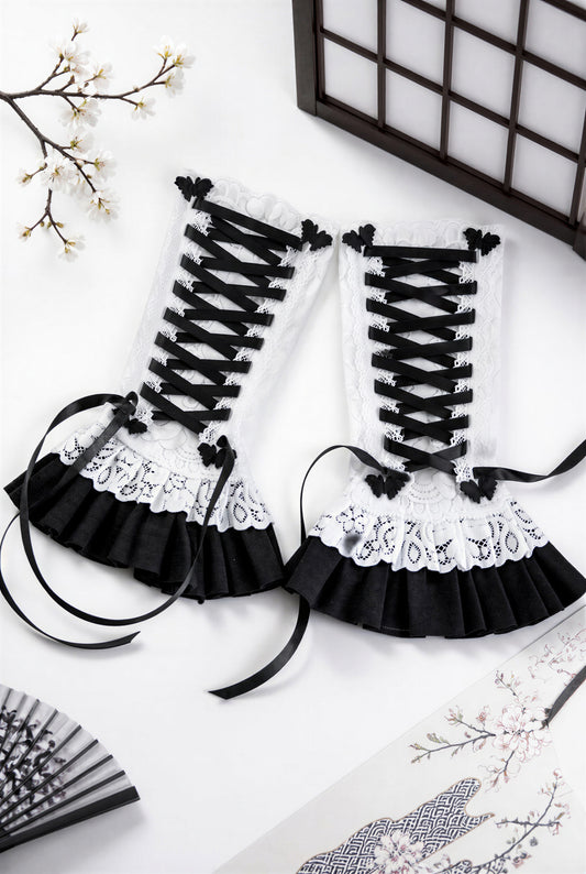 ein paar Gothic Lolita Armstulpen mit Bondage Schnürung, Schmetterlingen & Spitzen Röckchen. Sehr bequem und stylisch. Sie liegen in einem japanischen Ambiente flatlay im Bild, die Schnürung ist nicht zu einer Schleife gebunden, damit man die Schmetterlinge links und rechts daneben besser sehen kann. Sie sind für Damen gedacht.