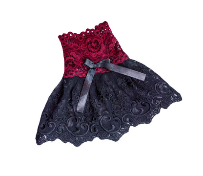 einzelne Spitze Stulpe, Manschette, flatlay flach auf dem Tisch liegend. So sieht man die Details wie Schleife und Musterung. Schwingendes Röckchen, leichter Glanz. Gothic Lolita, Folk, Karneval, Theater, Tanz & Bühnen geeignet. Robust, langlebig, form-, und farbstabil. Handarbeit auf Bestellung von Mouska Alfar, Hamburg.