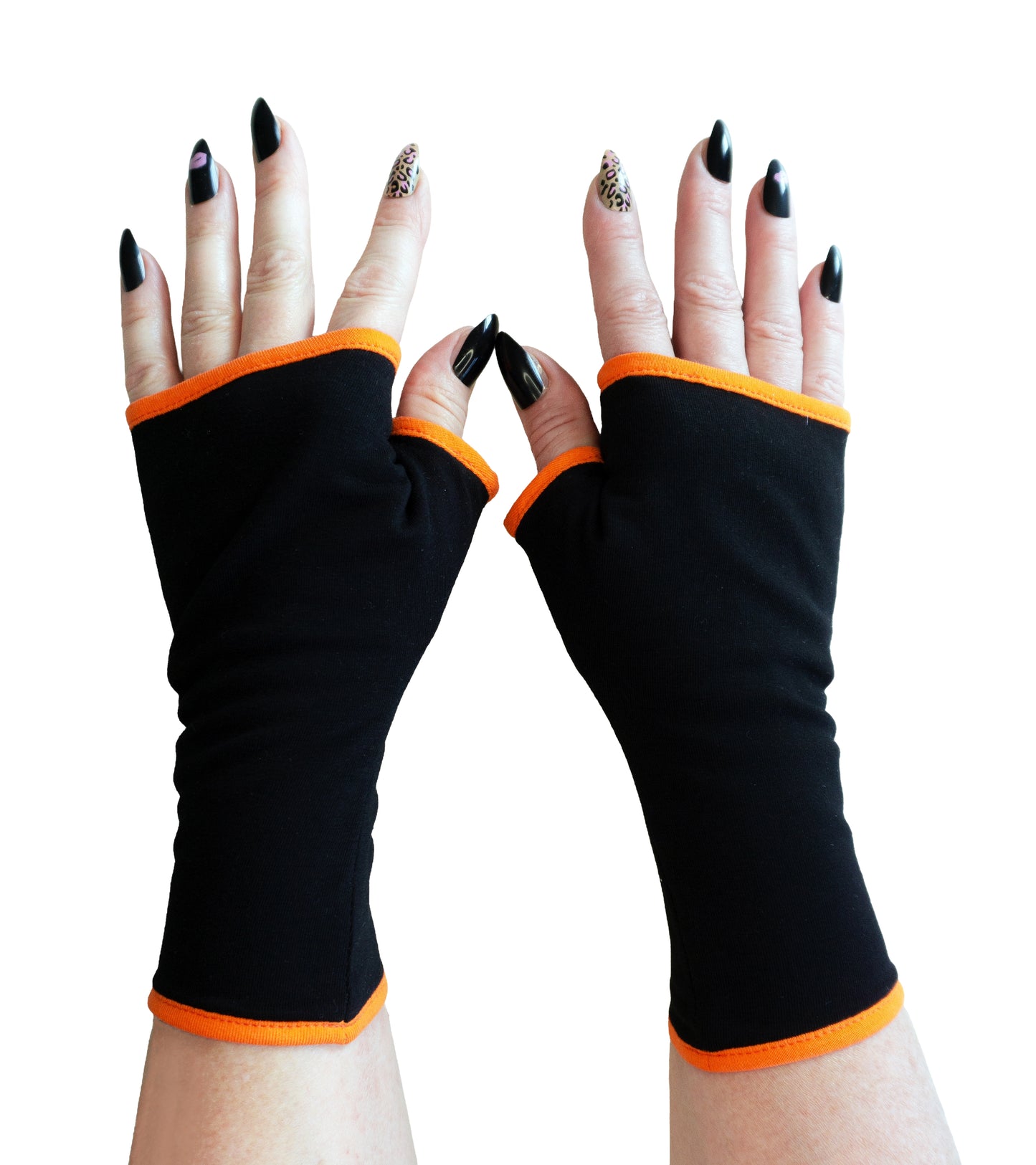 ein ganzes Paar Handschuhe in schwarz orange fotografiert. Die Pulswärmer werden aufwändig genäht mit Futter und Fake Paspel um die Säume.