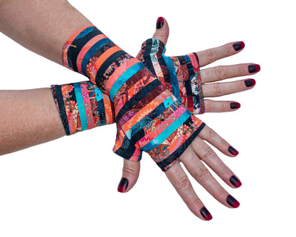 ein paar robuste, mit buntem gestreiften Muster Handschuhe ohne Finger, aus French Terry, dicker Baumwollstoff, leicht elastisch von Mouska Alfar, in Handarbeit hergestellt, unisex für die ganze Familie.
Auf dieser Seite ein paar übereinander liegende Damen Hände mit passend lackierten Fingernägeln.