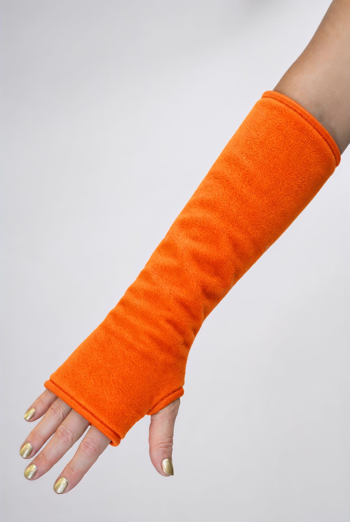 eine Fleece Armstulpe dargestellt an einem Frauenarm. Farbe neon orange. Leuchtet im Schwarzlicht. uv aktiv. Super für Goa Psy Trance Party fans, techno, tanzen, leuchten