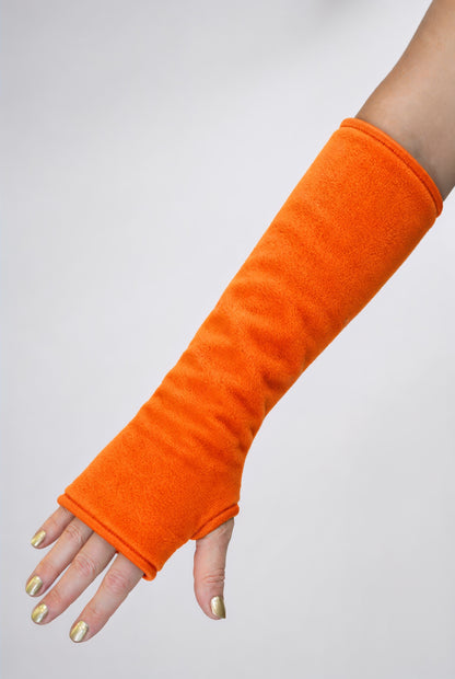 eine Fleece Armstulpe dargestellt an einem Frauenarm. Farbe neon orange. Leuchtet im Schwarzlicht. uv aktiv. Super für Goa Psy Trance Party fans, techno, tanzen, leuchten