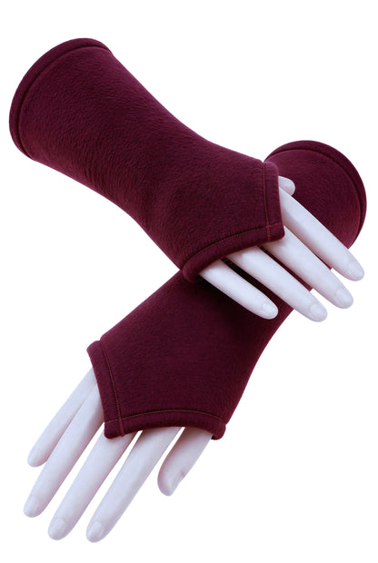 ein Paar flauschige Wichtel Armstulpen aus Fleece in weinrot an Modell Armen fotografiert, unlackierte Fingernägel. Eine einzelne Stulpe und darunter nochmal ein Paar übereinander gelegte Arme.
Die Stulpen sind halblang und nach vorn über den Handrücken wichtelig zugeschnitten, wie eine Elfe. Slow Fashion aus Deutschland von Mouska Alfar Harajuku Mode Design.