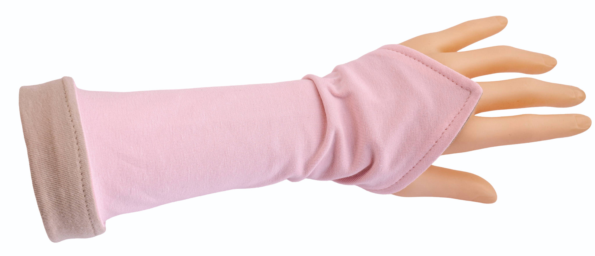 eine einzelne Wichtel Armstulpe an einer Hand fotografiert, leicht umgekrempelt am Arm in rosa beige, die rosa Seite ist oben, beige unten 