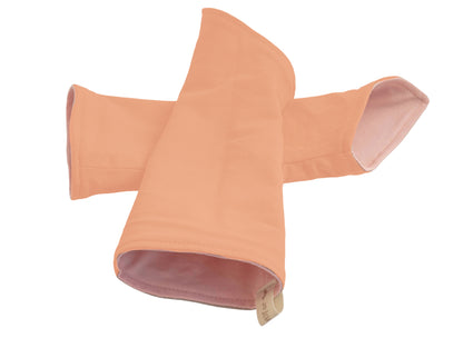 flatlay von einem Paar Wichtel Armstulpen aus Baumwolle zum Wenden, Farbe rosa pfirich