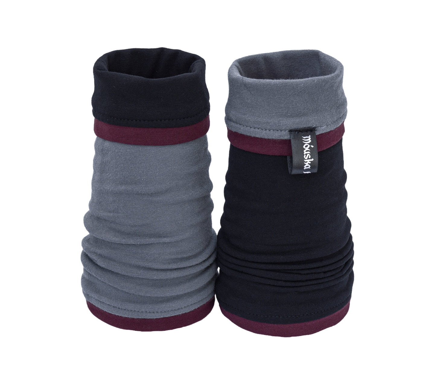 colorblock Armstulpen Nikita wendbar & wandelbar in den Farben grau schwarz bordeaux, aus Baumwolljersey. Hier auf dem Tisch fotografiert ohne Hände. Eine Stulpe Oberseite grau, die andere schwarz, beide umgestülpt so dass man auf der grauen ein großes Stück schwarz sieht und auf der schwarzen ein Stück grau. super stylisch. mit eingenähten Paspeln an allen Säumen.